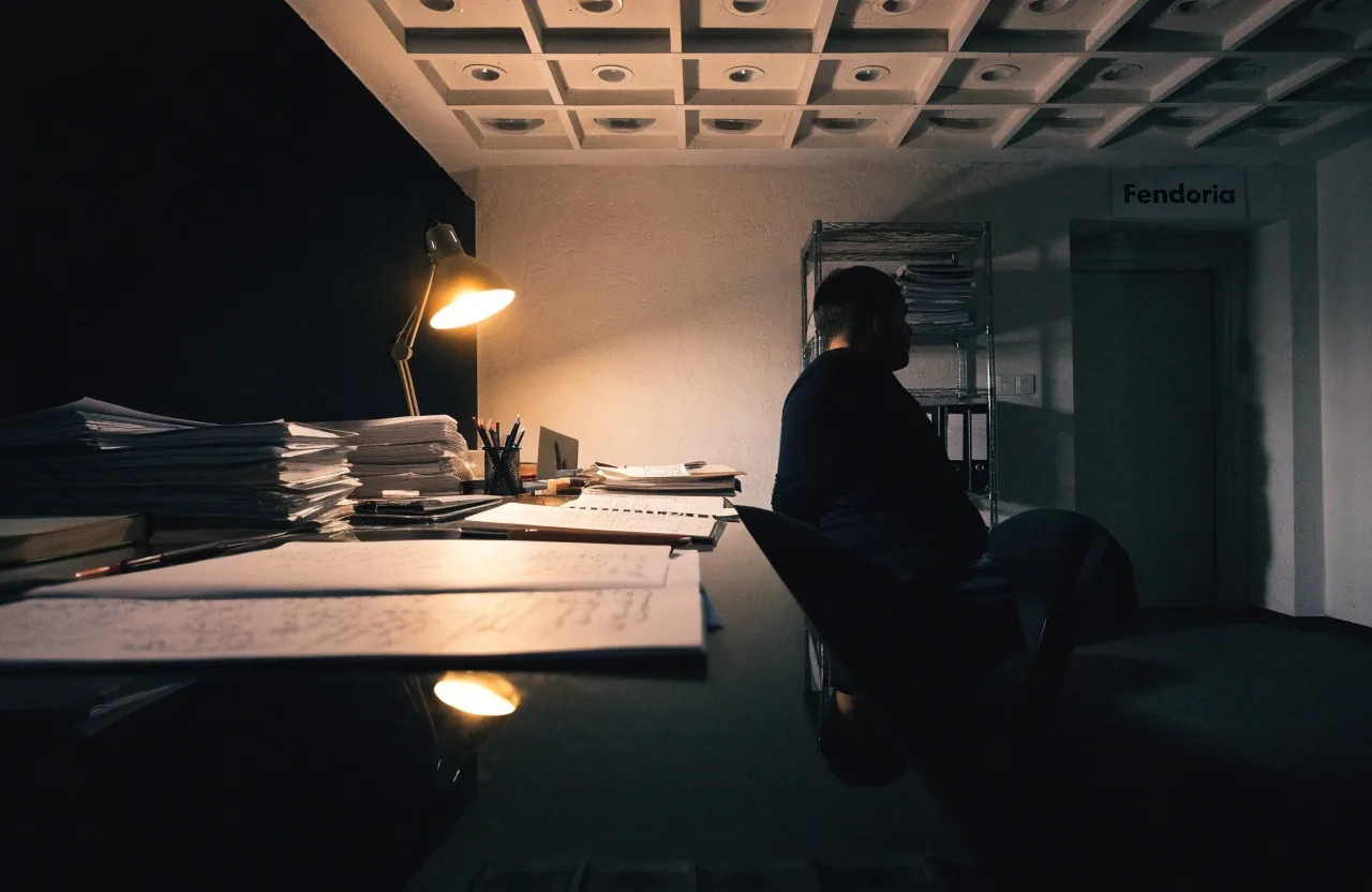 An overnight desk at the Fendoria politics office, lit by a single lamp